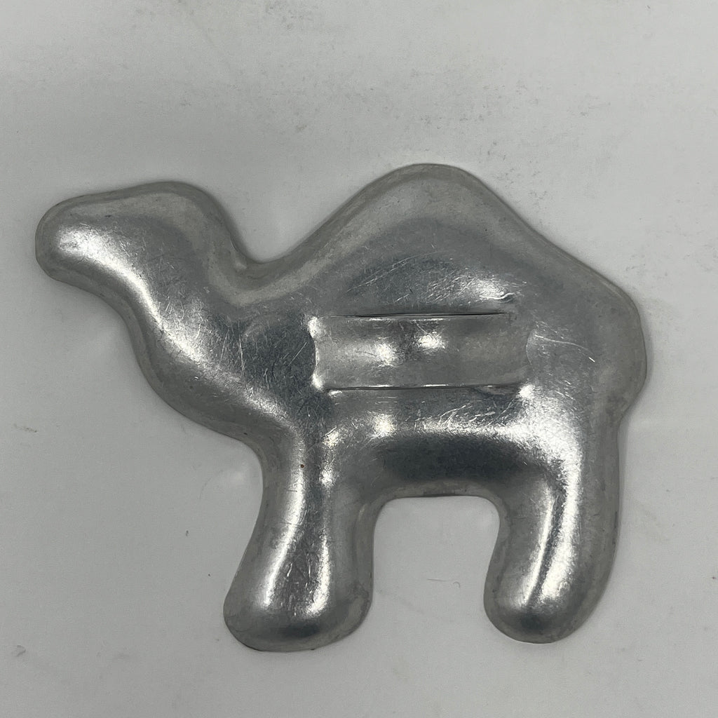 Mid century metal cookie cutters in various shapes including a camel, moons, and stars.