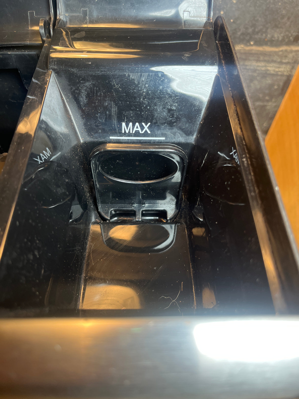 Close-up of the 12-cup Cuisinart coffee maker's plastic water reservoir, showing the MAX fill-level mark and small spout, reflecting detailed appliance design.