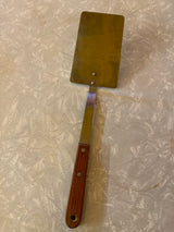 Flat thin steel spatula with wood handle - vintage, featuring a stainless-steel blade, angled handle, and riveted shank, ideal for flipping and transferring foods.
