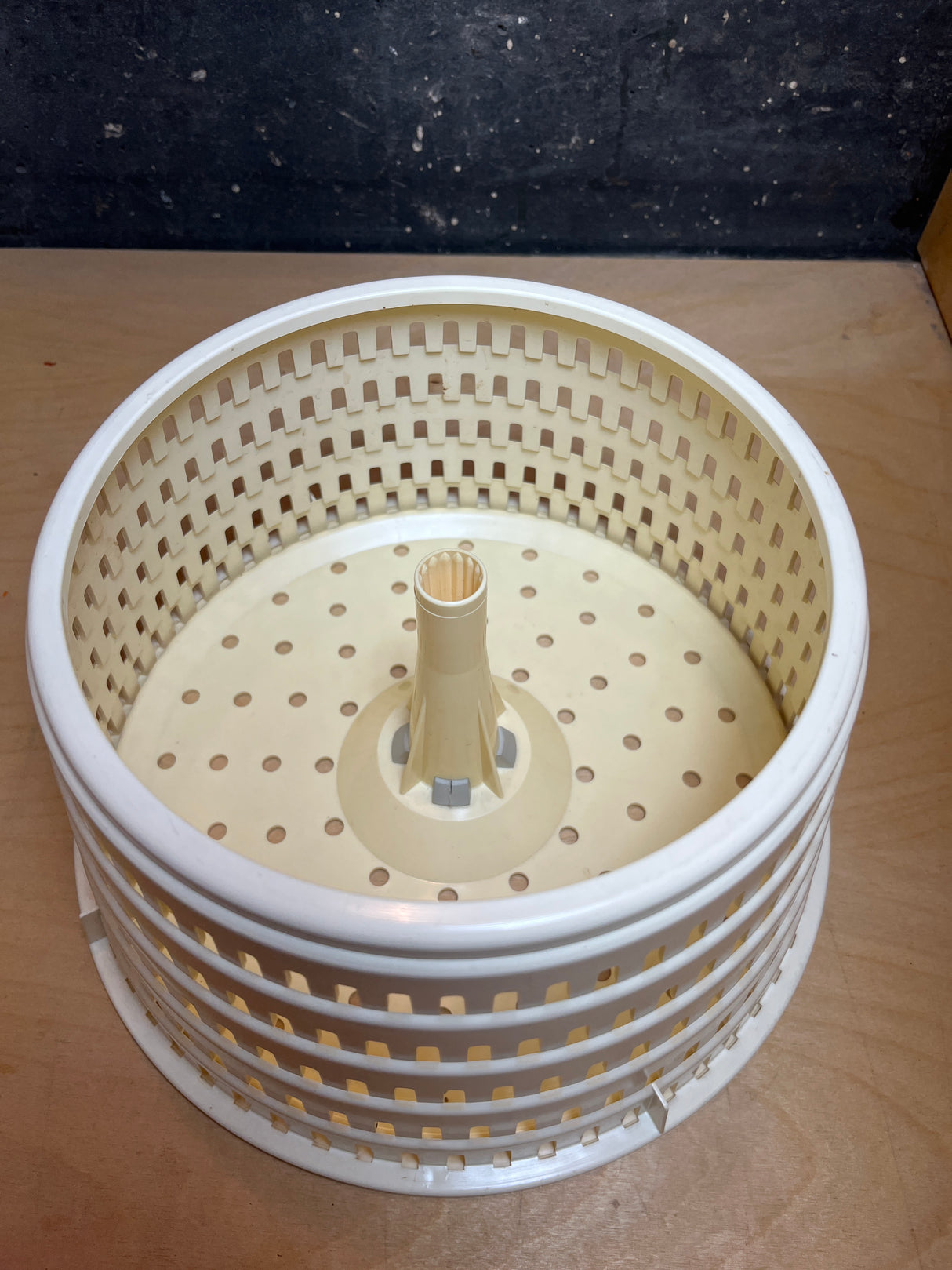 Spinner's perforated inner basket, featuring a central hub with splines and numerous holes for efficient water drainage during the drying process.