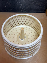 Spinner's perforated inner basket, featuring a central hub with splines and numerous holes for efficient water drainage during the drying process.