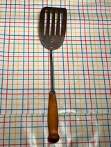 Flat thin steel slotted spatula with wood handle - vintage, shown lying flat, features a long handle, thin edge, and slots for easy flipping and grilling.