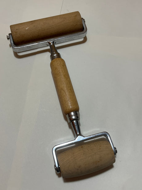 Pampered Chef double rolling pin for pizza and dough features a two-sided wooden cylinder design, metal frame, and central wooden handle, ideal for printmaking and crafts.