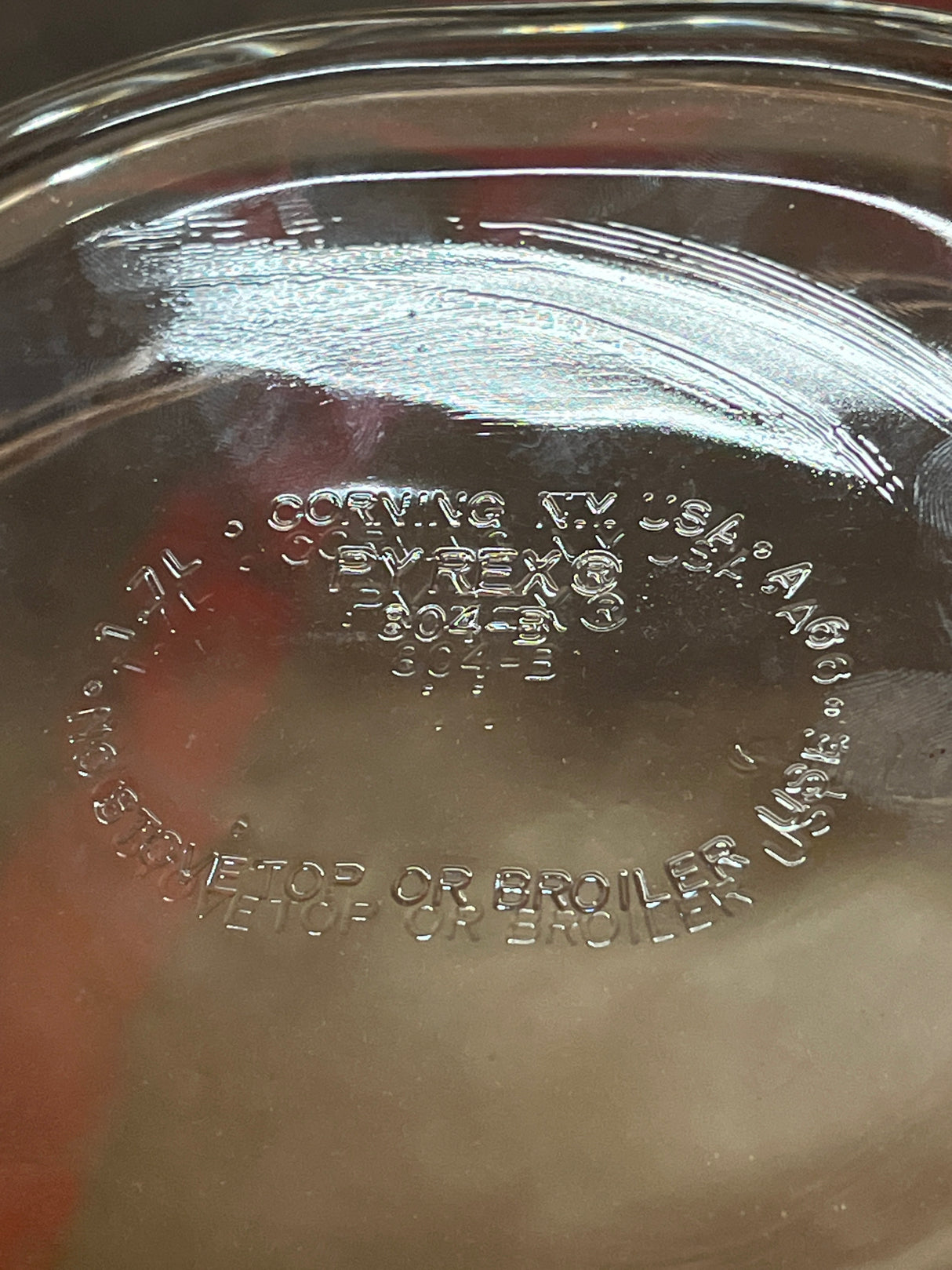 Underside view of Oval casserole baking dish with lid - PYREX 804-B, showcasing embossed markings including “Pyrex,” model numbers, and usage warnings.