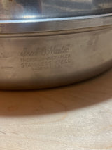 Seal-O-Matic Thermium Multi-Plex 18-8 Stainless Steel 11” Skillet with Lid, featuring embossed branding and sturdy resin handles, promises durability and even heat distribution.