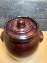 Vintage two-toned ceramic pot with lid featuring a rich glazed top, small side handles, and a practical size for storing dry goods on the countertop.