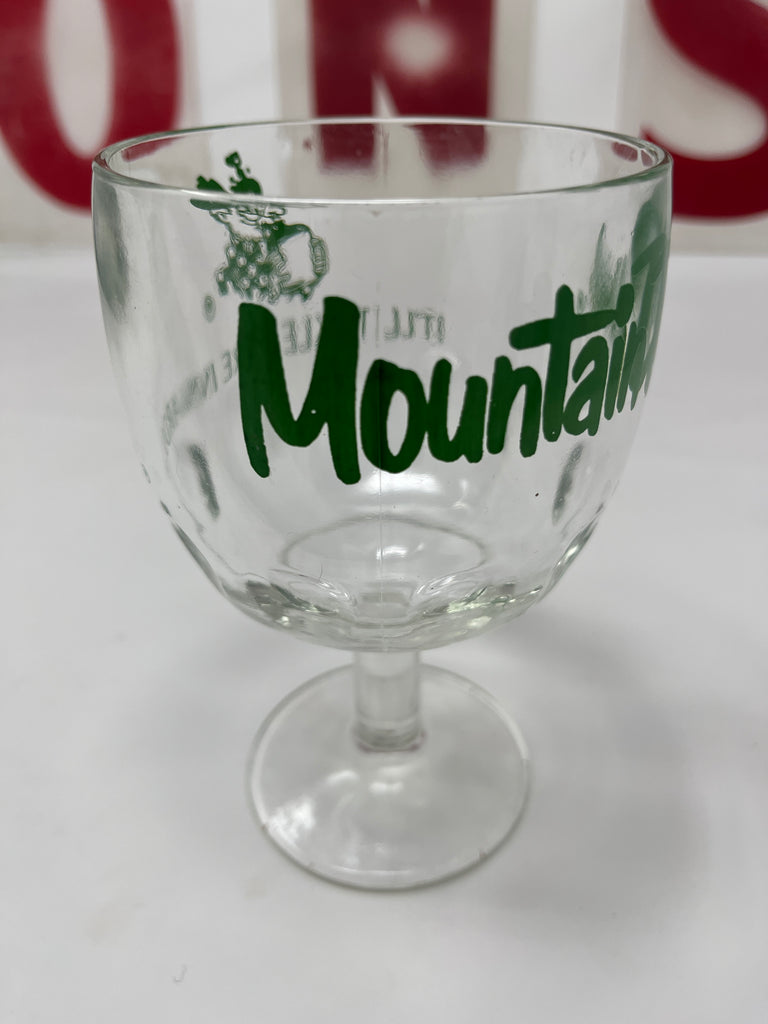 Vintage Mountain Dew goblet with It'll tickle yore innards inscription, designed for beverage enthusiasts. Close-up view highlighting green writing on clear glass.