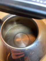 Whistling tea kettle - Kitchenaid 2 quart / 1.9L stainless steel viewed from above, showcasing the empty interior with a cushioned black handle partially visible.