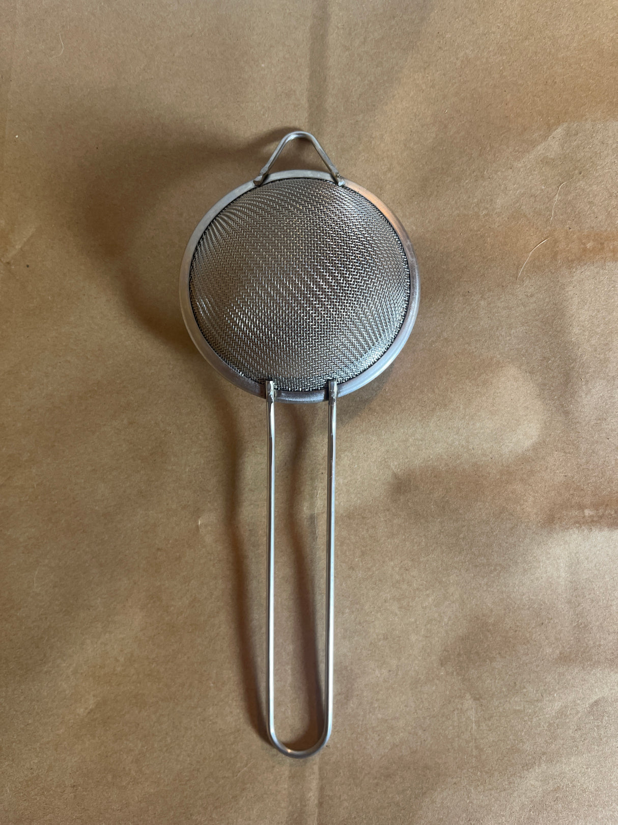 Stainless steel mesh strainer with loop handle, 2.5 inch, ideal for steeping tea or sifting powders, features a long handle and hanging ear for convenience.