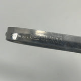 Close-up of EKCO stainless steel vegetable peeler with floating blade. Curved tip for precise cuts, inscribed with “NEE ACTION PAT. NO 2232940”.