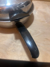 Seal-O-Matic Thermium Multi-Plex 18-8 Stainless Steel 11” Skillet with Lid features black handles, flat base, and secure lid for even heating on a wood countertop.