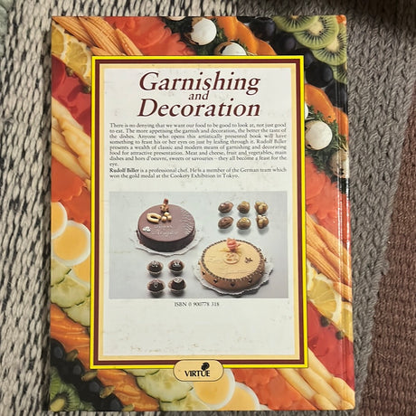 Garnishing and Decoration book on a carpet, showcasing artistic food presentation techniques with insights from chef Rudolf Biller.