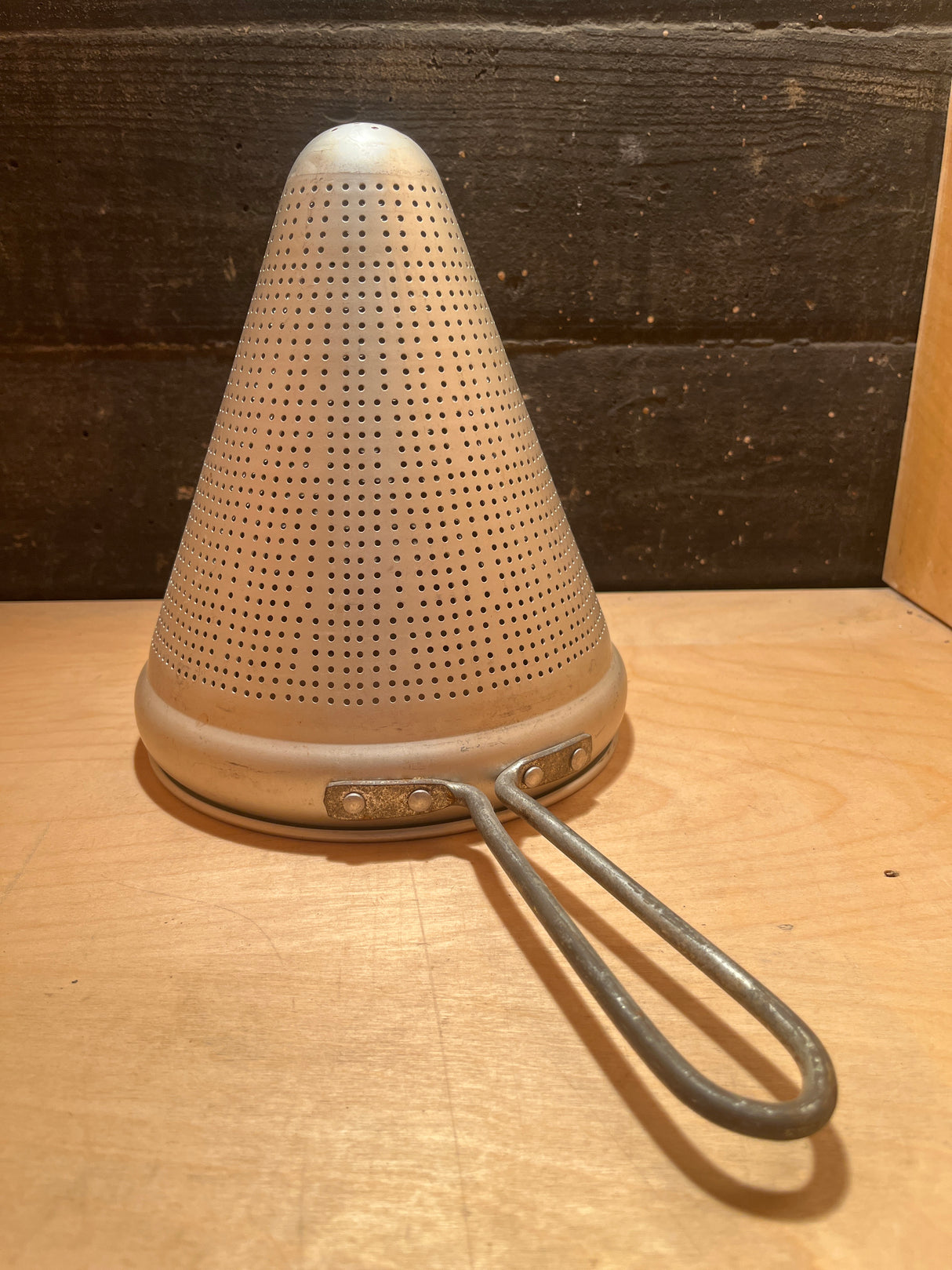 Cone sieve strainer - aluminum unknown brand; a sturdy, vintage metal kitchen tool with a perforated cone shape and looped handle, ideal for canning and preserving.