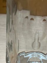 Close-up of an Anchor Hocking vintage clear thumbprint dimple glass mug, showcasing the interior with semi-circular notches and a small mold-mark protrusion.