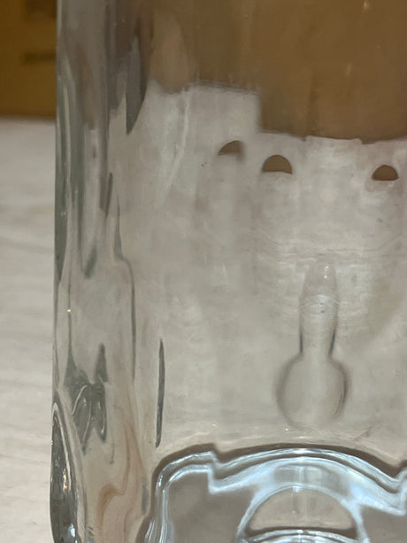 Close-up of an Anchor Hocking vintage clear thumbprint dimple glass mug, showcasing the interior with semi-circular notches and a small mold-mark protrusion.