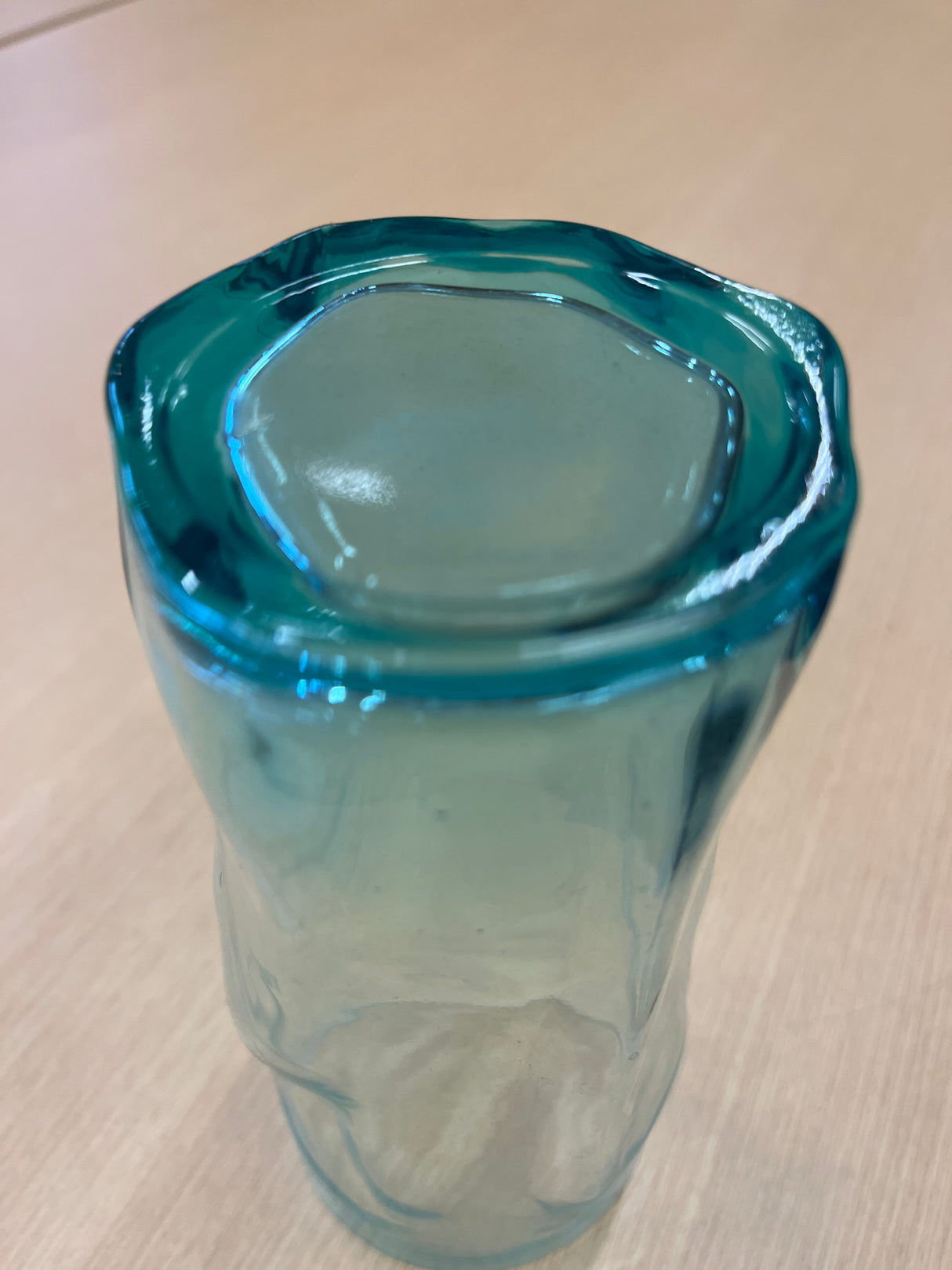 Bormili glass showcasing its elegant, transparent form, filled with liquid, resting on a table, highlighting its sleek design for indoor use.