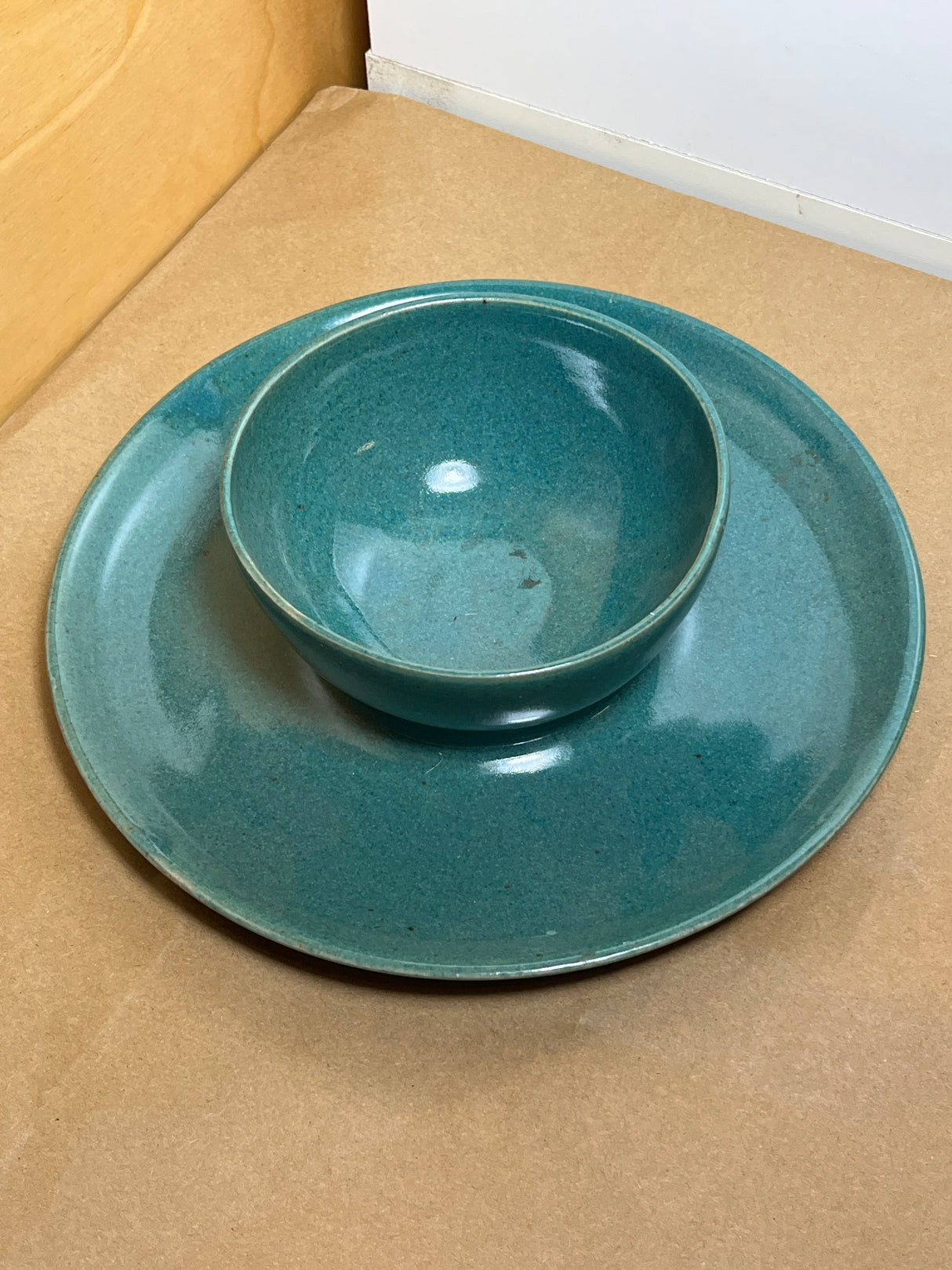 McEvoy ceramic dip dish with teal glaze displayed on a matching plate, highlighting its handcrafted design on a light wood surface.
