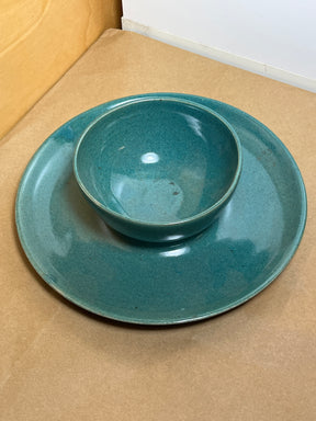 McEvoy ceramic dip dish with teal glaze displayed on a matching plate, highlighting its handcrafted design on a light wood surface.