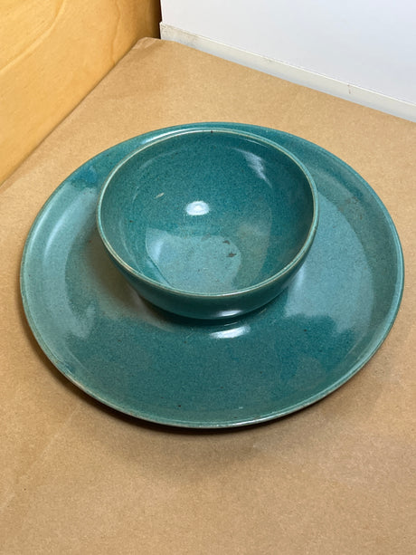 McEvoy ceramic dip dish with teal glaze displayed on a matching plate, highlighting its handcrafted design on a light wood surface.