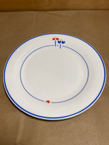 Rival Designs Tulip dinnerware collection Lot 3078 features a white ceramic plate with blue rings and stylized flower accents, embodying elegant simplicity.