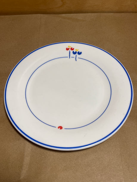 Rival Designs Tulip dinnerware collection Lot 3078 features a white ceramic plate with blue rings and stylized flower accents, embodying elegant simplicity.