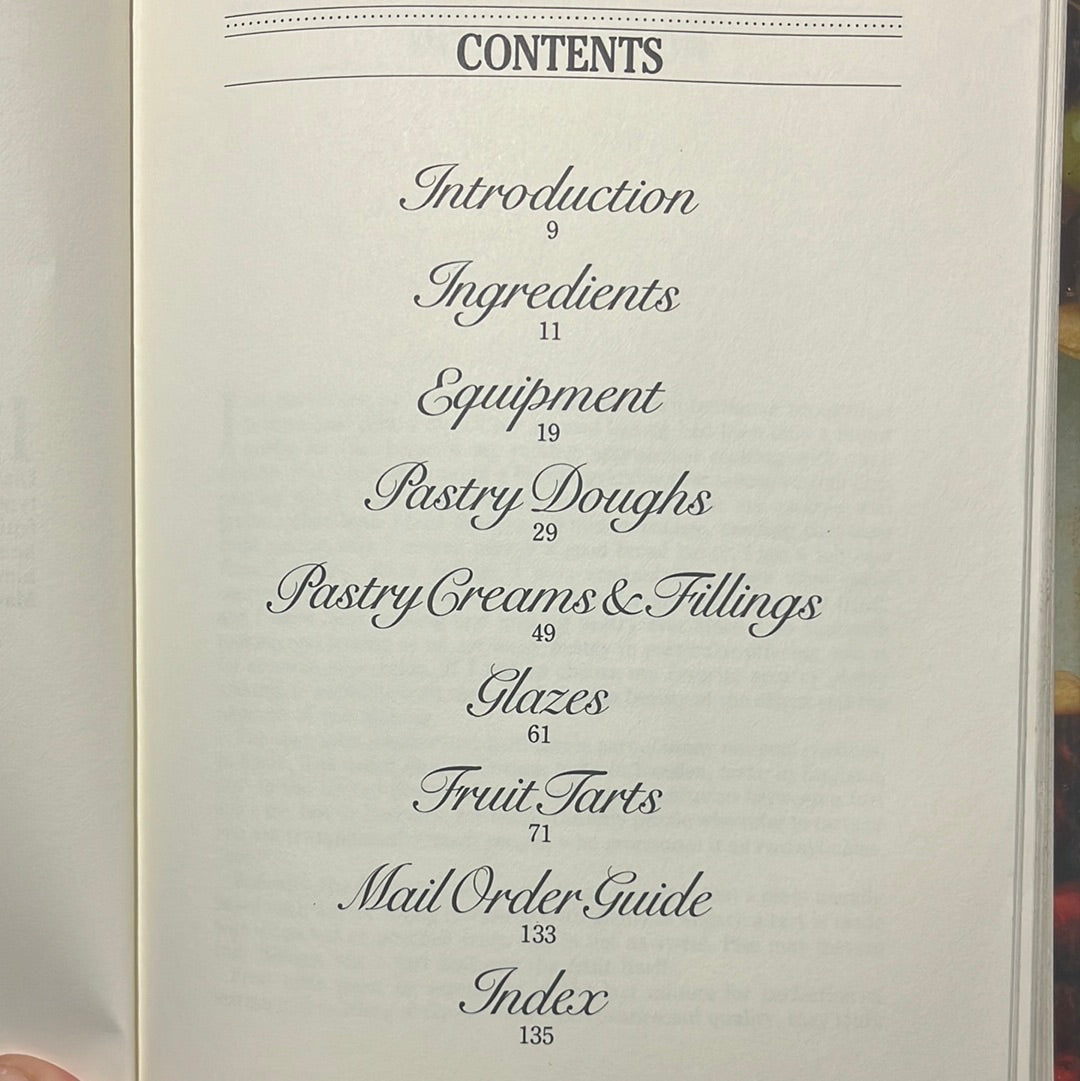 Pamella Z. Asquith's Fruit Tart Cookbook open, showcasing pages with text and illustrations on pastry techniques and fruit tart recipes.