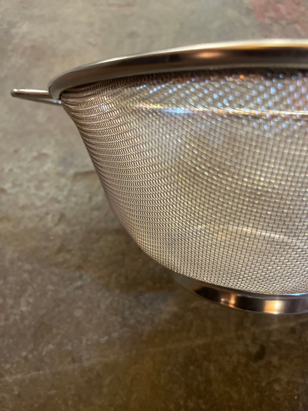 Basket mesh strainer with two handles, featuring durable stainless steel fine mesh for effective straining, ideal for draining pasta and rinsing vegetables.