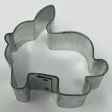 Mid century metal cookie cutters in various shapes, including a rabbit and other animals, on a white surface.