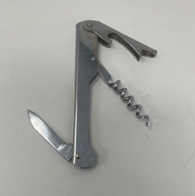 A metal knife with a corkscrew, a versatile pocket bottle opener ideal for household tasks. Close-up details of the tool's functionality.