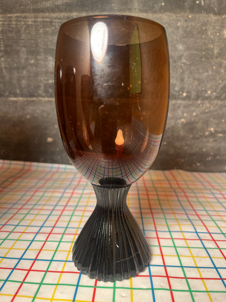 Set of 5 brown glass water goblets - vintage Lenox Nutmeg line, featuring a fluted dark stem and amber-tinted bowl on a grid-patterned tablecloth.