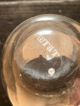 Double-walled insulated glass mug - BTäT, featuring a clear domed lid with “BITÄT” print and a central vent, resting on a wooden surface.