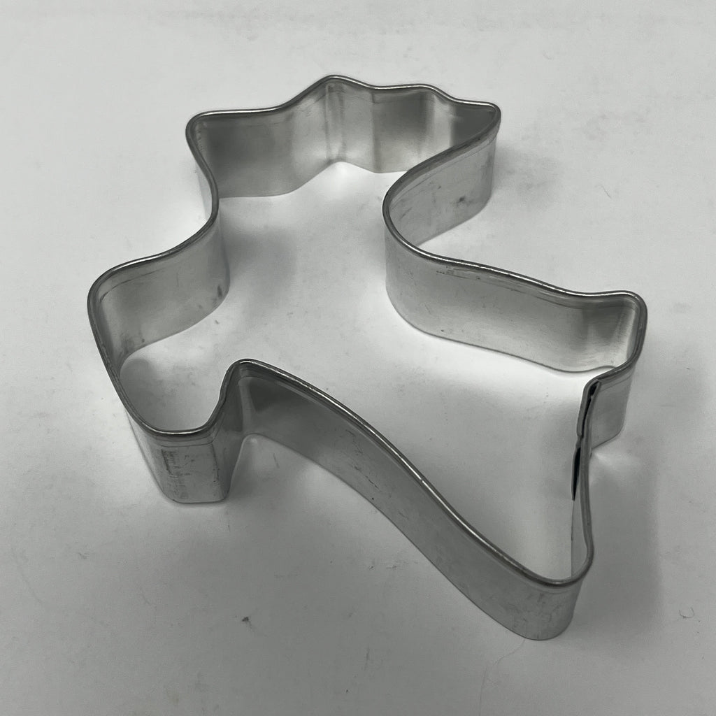 Mid century metal cookie cutter in ghost shape on white surface.