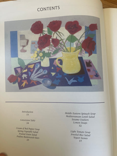 Cover of 'Still Life with Menu' cookbook by Mollie Katzen, featuring a painting of flowers in a yellow pitcher.