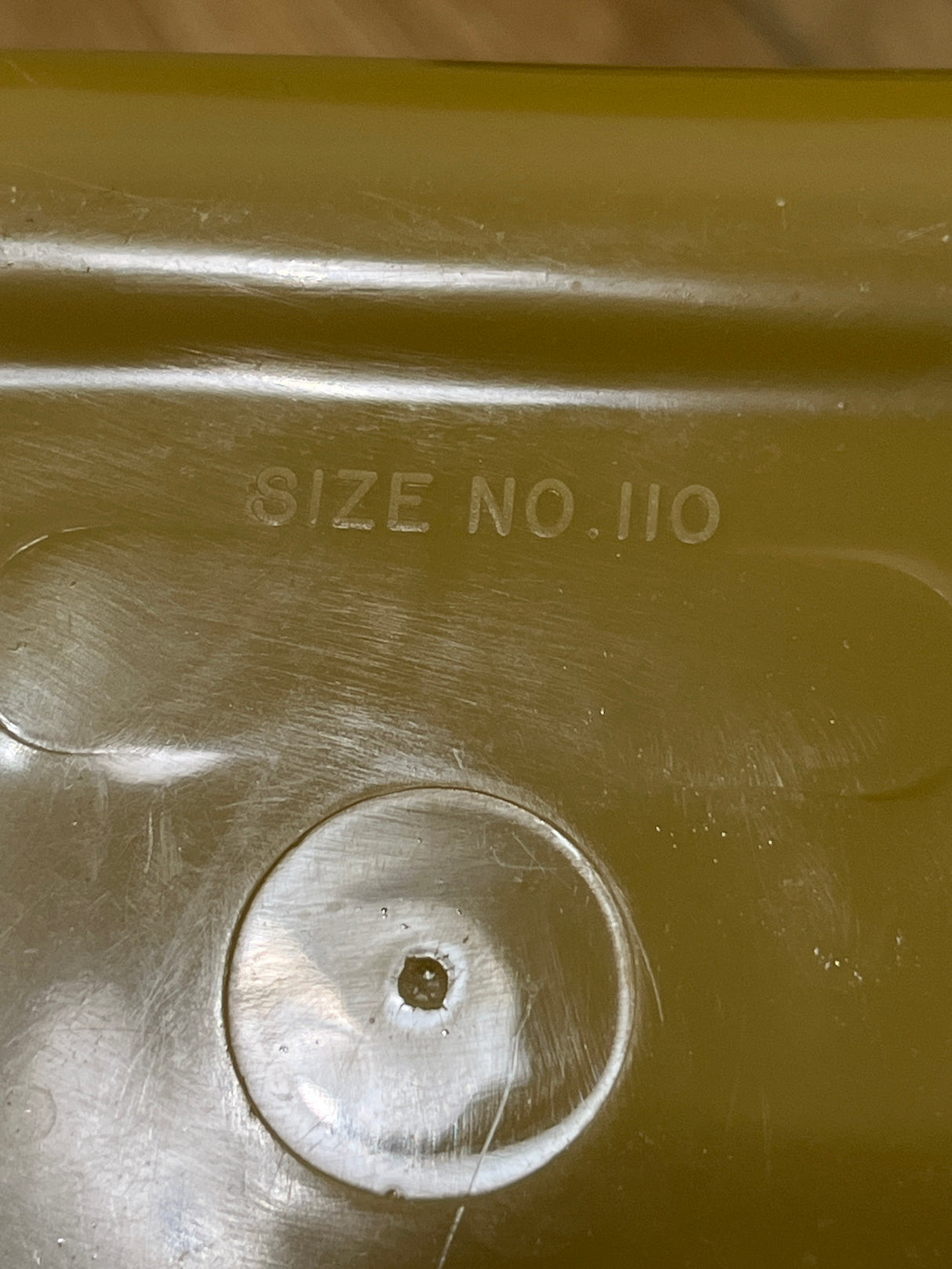 Close-up of an olive-green lid with SIZE NO. 110 embossed, part of the Melmac set of 4 retro food storage containers.