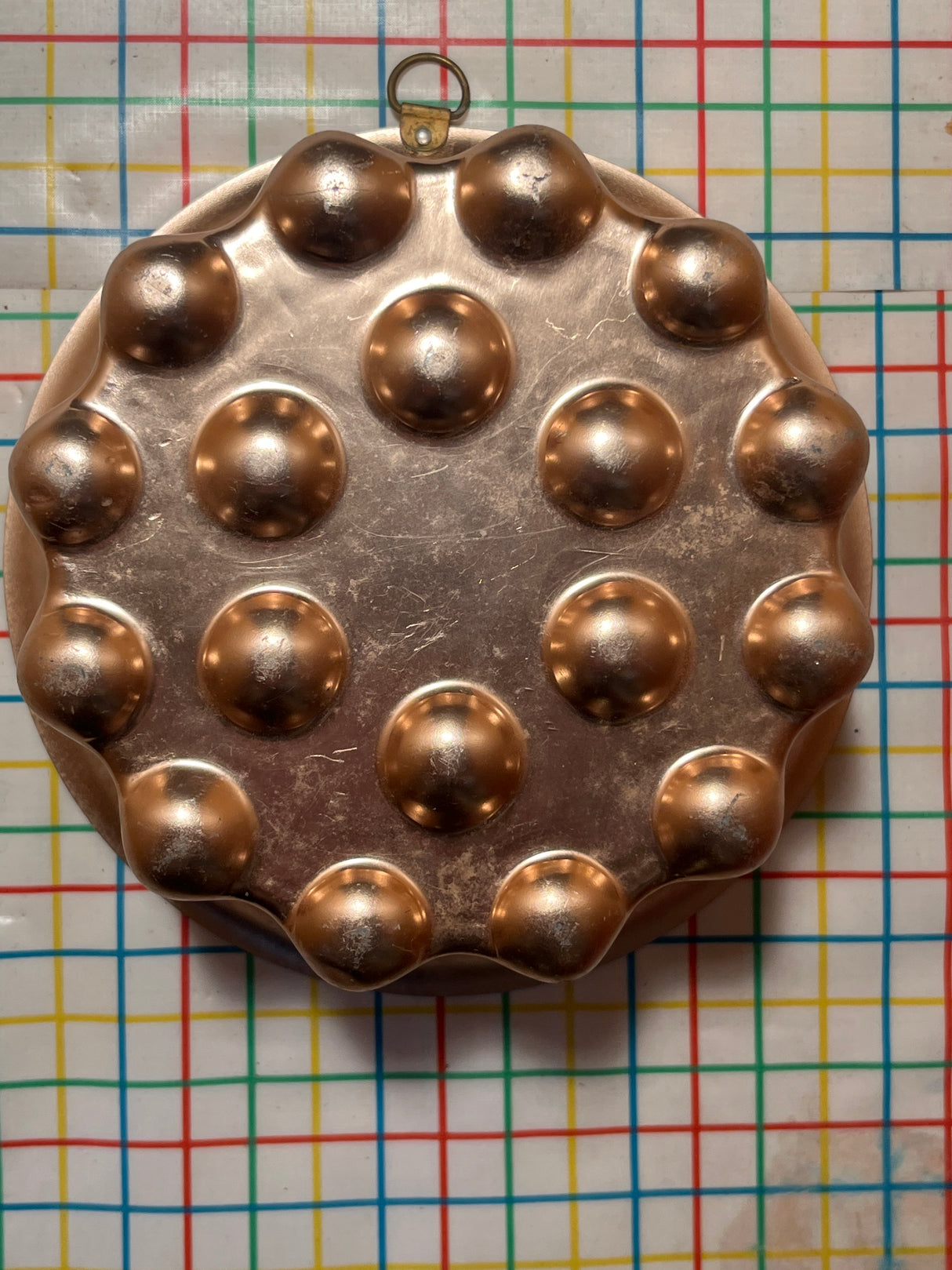 Copper-lined aluminum mold for jello with dome-shaped hemispheres, featuring a hanging ring for display, perfect for crafting elegant gelatin or cake creations.