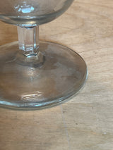 Mini hurricane drinking glass with a short, angled stem shown close-up on a wooden surface, perfect for serving strong cocktails and after-dinner drinks.