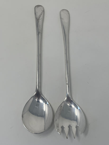 Italian silver plated salad tongs with minimalist design, made in the 1970s, showing slight tarnish from use, displayed on a white surface.