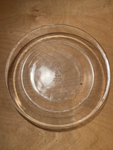 Vintage glass Fire-King Anchor Hocking 460 pie plate on wooden surface, showcasing its clear, round design ideal for even baking.
