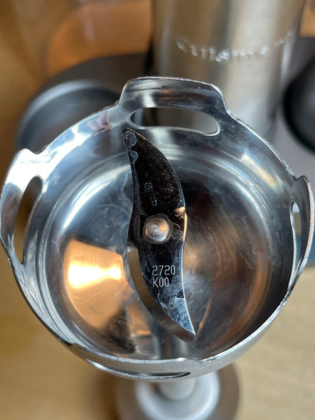 Close-up of Cuisinart stick blender and whisk set HB-800PC’s stainless-steel blade assembly, resembling a hand-held appliance component, highlighting its durability and precision.