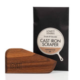 Hard Wood Cast Iron Pan Scraper set, featuring a wedge-shaped hardwood scraper engraved with “Lovett Sundries,” packaged in a black sleeve labeled “Gentle & Durable.”