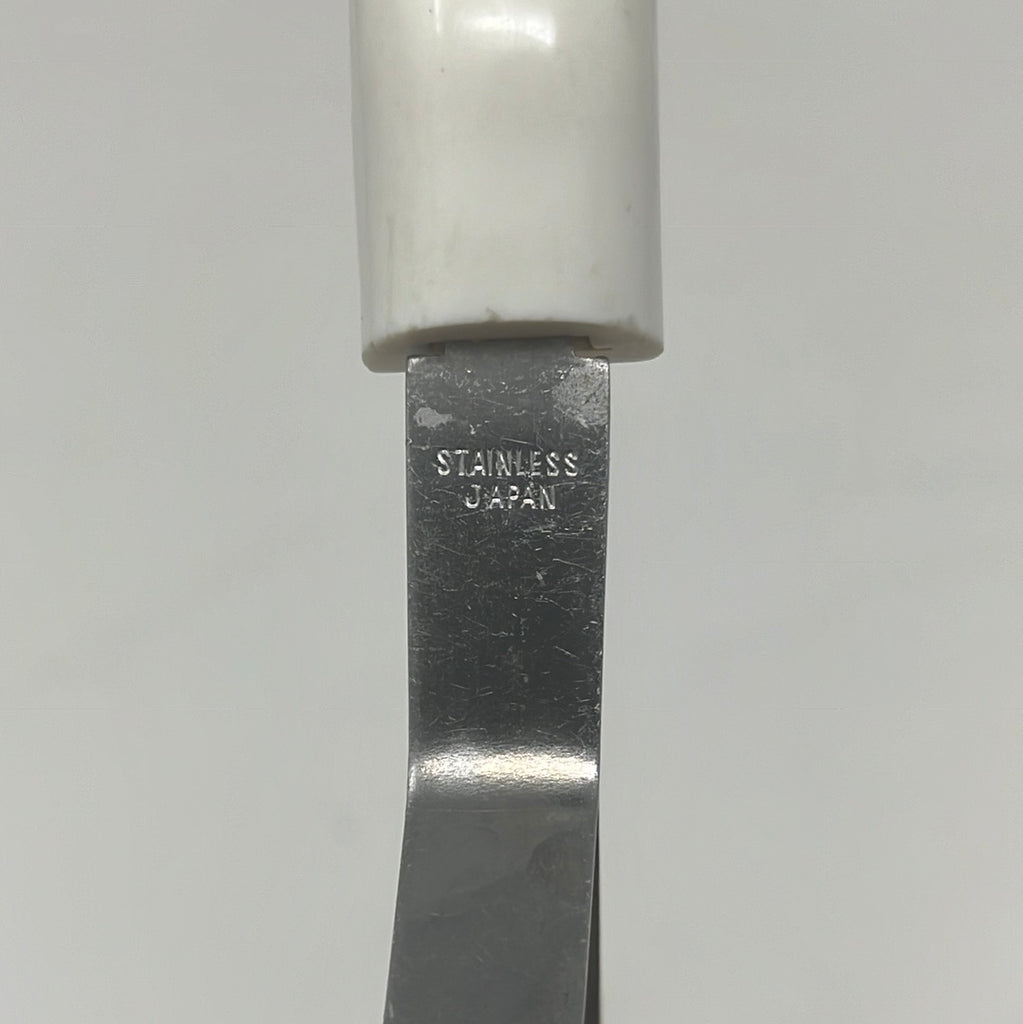 Potato masher with floral-patterned handle, close-up of tool with silver plate and cylinder.