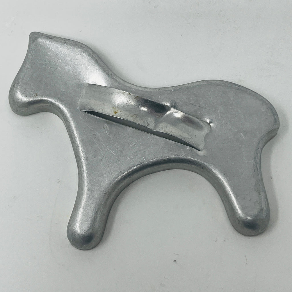 Mid century metal cookie cutter of a horse on white surface. From Spoons Kitchen Exchange. 