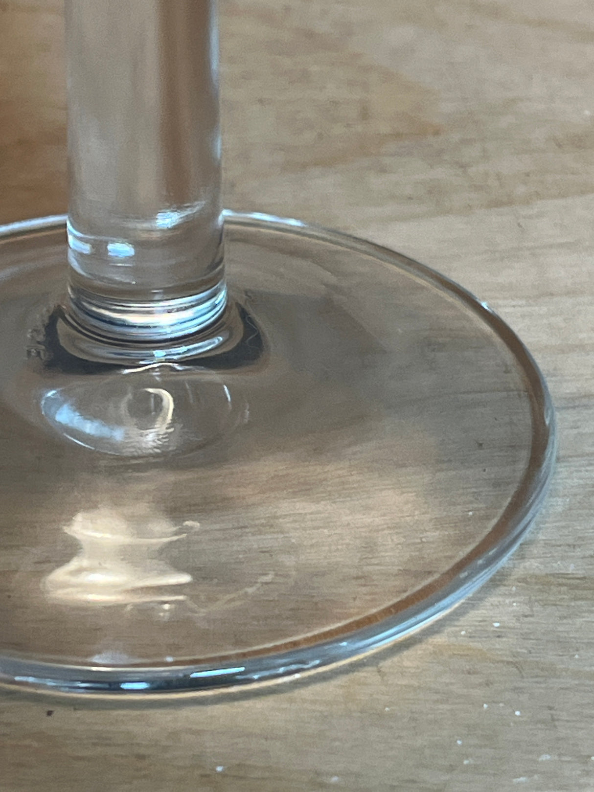 Libbey Embassy 6.5oz wine glass featuring a clear glass foot and stem, showcasing its dainty, chip-resistant design on a wooden surface.