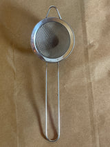 Stainless steel mesh strainer with loop handle, 2 inch, featuring a fine mesh for straining teas and small tasks, includes a hanging ear for easy use.
