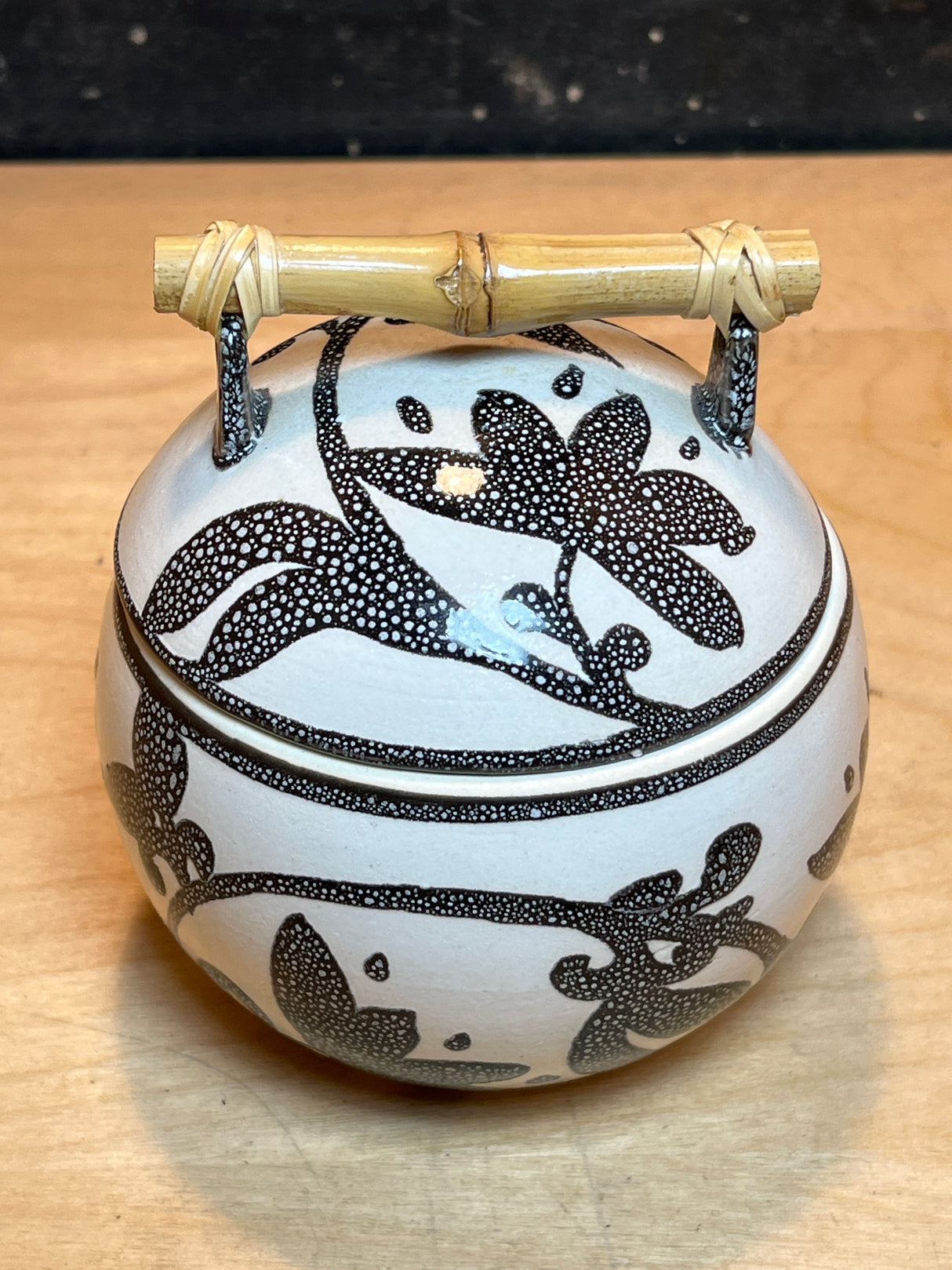 Ceramic sugar bowl with lid, featuring a black floral pattern and bamboo handle, part of a set of 8 white mugs and bowl.