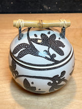 Ceramic sugar bowl with lid, featuring a black floral pattern and bamboo handle, part of a set of 8 white mugs and bowl.