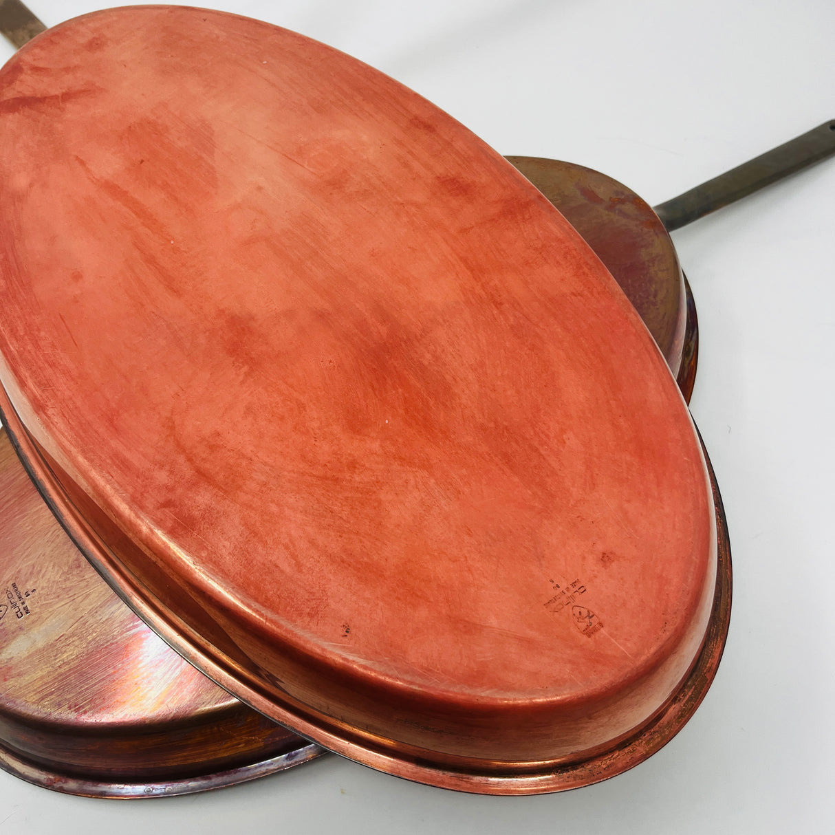 Oval copper sauté pans with brass handles by Spring Culinox Switzerland showing copper undersides. From Spoons Kitchen Exchange.