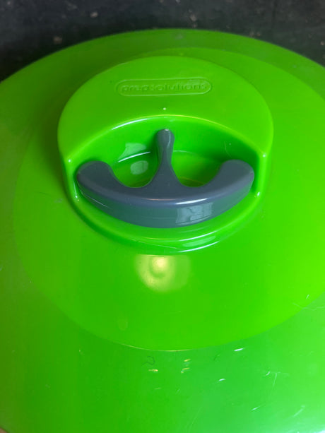 Easy Pull Salad Spinner lid by Prep Solutions, featuring a bright green cover with a gray vent handle, designed for efficient steam release and storage.