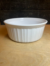 Corning Ware F-5-B 1.6L casserole baking dish with round shape, fluted sides, ideal for baking and reheating, shown on a wooden surface.