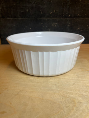 Corning Ware F-5-B 1.6L casserole baking dish with round shape, fluted sides, ideal for baking and reheating, shown on a wooden surface.
